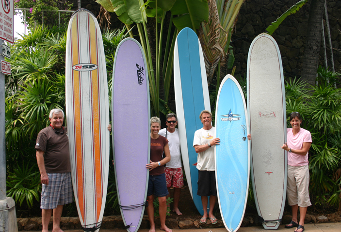 A group of people standing next to surfboards.