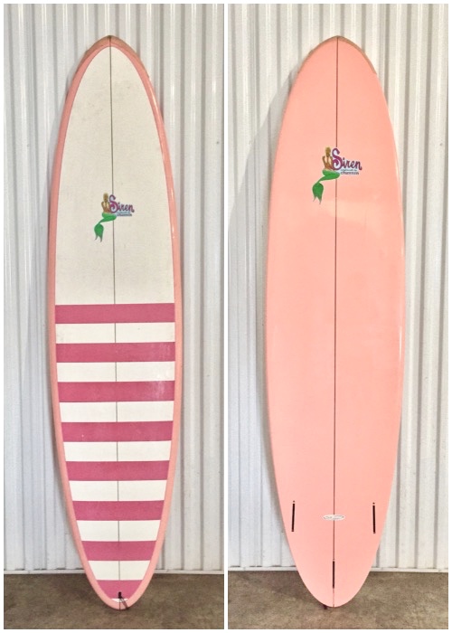 Two surfboards hanging on the wall in a room.
