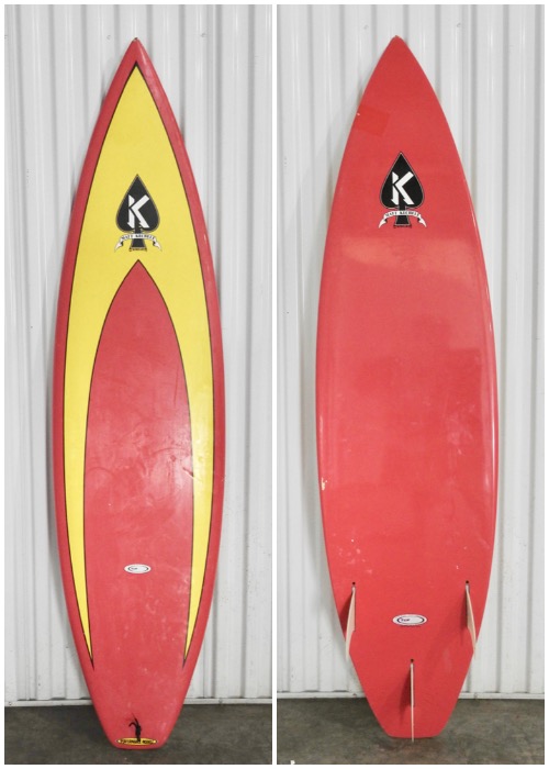 Two surfboards hanging on a wall in the corner.