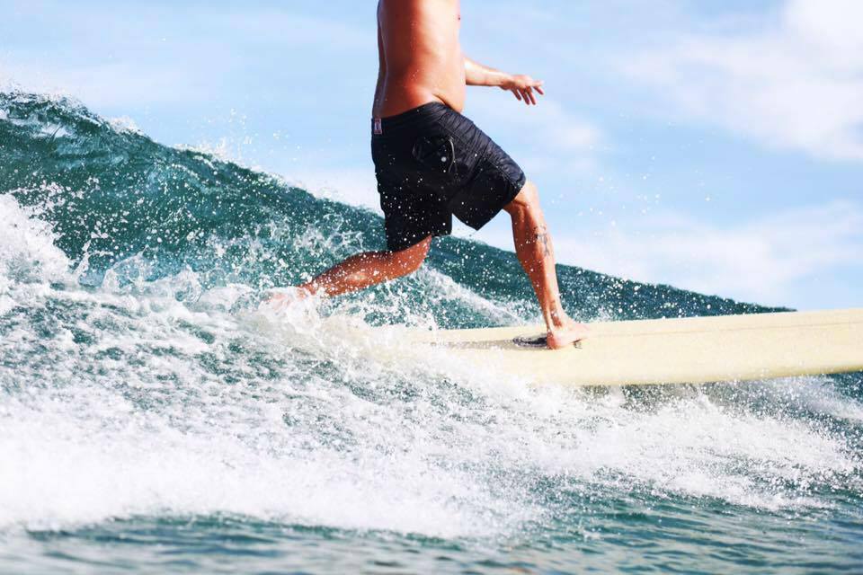 A man riding a wave on top of a surfboard.
